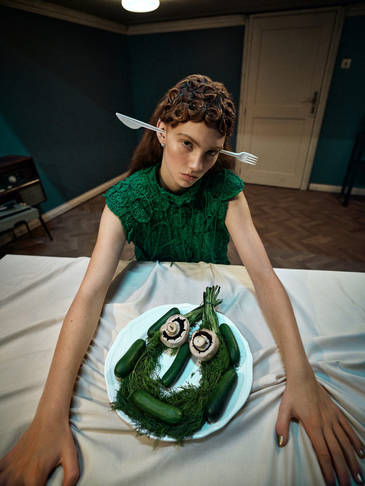 Surreal wide-angle portrait of a woman with cutlery in her ears and a face composed of vegetables on her plate, a bold mix of fashion and staged photography with surrealist influences. Dolce Vita by Matus Toth, Woman Portrait Gallery.